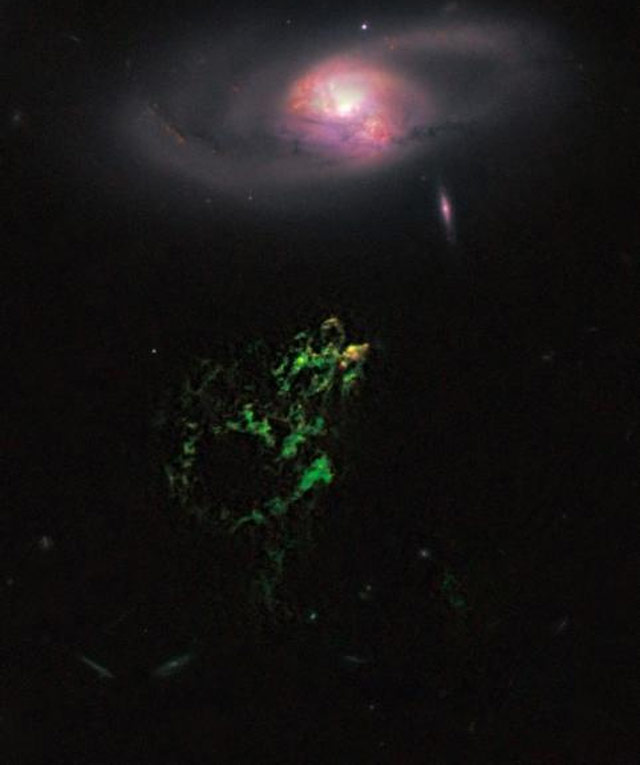 El Objeto de Hanny parece flotar debajo de una galaxia espiral, en esta imagen tomada por el telescopio Hubble, en la que se observa en el extremo superior de la nube verde la regi�n de formaci�n de estrellas.