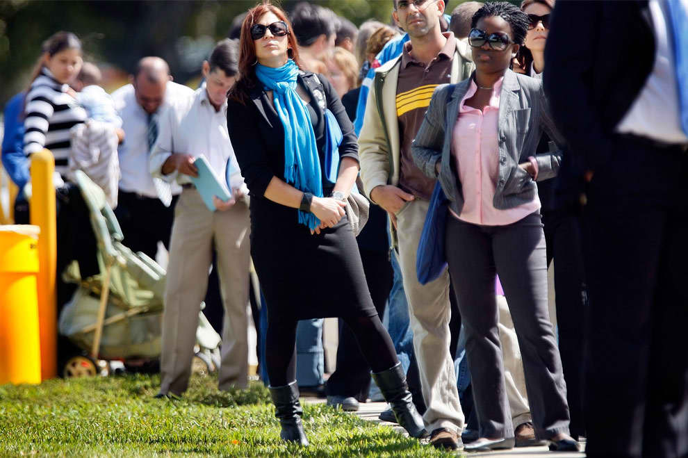 Cientos de personas hacen fila para buscar empleo en una feria de empleo en el condado Miami Dade