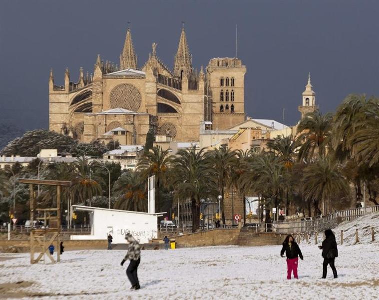 Varias personas juegan en la playa de Palma tras la fuerte nevada que ha ca�do en Mallorca. foto: Montserrat T.Diez
