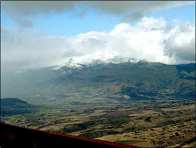 El volc�n Cayambe se ve parcialmente nublado por una espesa capa de nubes mientras una borrasca se aproxima. N�tese la parte superior de la foto: no hay lluvia, es decir la gran parte de lluvia ser� atrapada por el Cayambe y luego regar� los campos, los beneficios de los volcanes.
