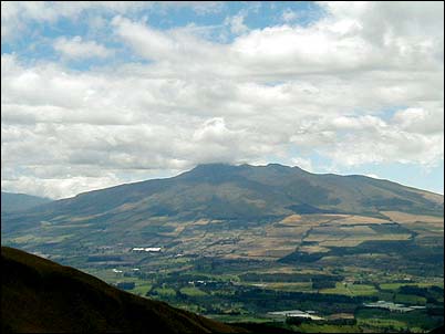 Aqu� podemos ver el volc�n Coraz�n levant�ndose al suroeste del valle de Machachi, las puntas que se ven en la cima son los restos de la caldera de este volc�n, una peque�a elevaci�n hacia el este del volc�n apenas perceptible en esta foto denominada La Moya parece ser un cono de escorias.
