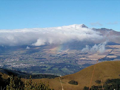 Un mar de nubes arremete desde el sur al Coraz�n provocando tambi�n un arcoiris en una ma�ana despejada sobre el volc�n Coraz�n. La ventaja del volc�n Pasochoa es el hecho de ser un excelente balc�n para visualizar muchas otras monta�as.
