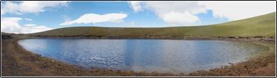 Foto desde la orilla de la laguna, esta laguna tiene un di�metro m�ximo de unos 100 metros y quiz� una profundidad m�xima de uno o dos metros, hoy es un abrevadero de ovejas y vacas y es un lugar de singular belleza. Los sedimentos de esta laguna han servido para fechar la ocurrencia de erupciones de otros volcanes.
