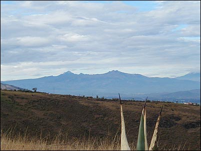 Aqu� m�s claramente se pueden ver los volcanes Quilinda�a a la izquierda, Sincholagua a su derecha y parcialmente al Cotopaxi. Se pueden observar tambi�n parte de los valles que rodean a estos volcanes.
