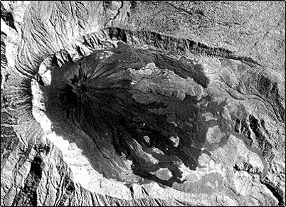 Vista a�rea del volc�n Reventador, se aprecian claramente los flujos recientes de lava y lahares que han descendido del volc�n, tambi�n se aprecia la antigua caldera del Reventador, esta a su vez parece haber crecido sobre los restos de otra.
