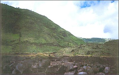 Flujo de lodo reciente de la erupci�n actual en la v�a a Ba�os, el volc�n se encuentra tras las nubes. Se pueden ver rocas de gran tama�o procedentes del cr�ter, algunas son de desconcertante di�metro, afortunadamente los flujos no han causado mayores da�os.
